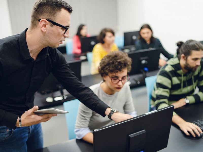 man showing woman how to use computer